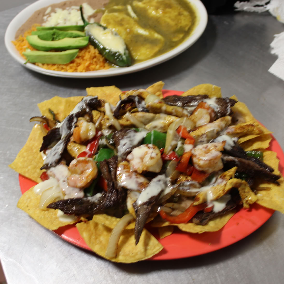 A top view of assorted Mexican tacos with lime, cilantro, and fresh toppings.